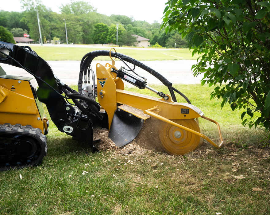 A stump cutter attachment removing  a stump