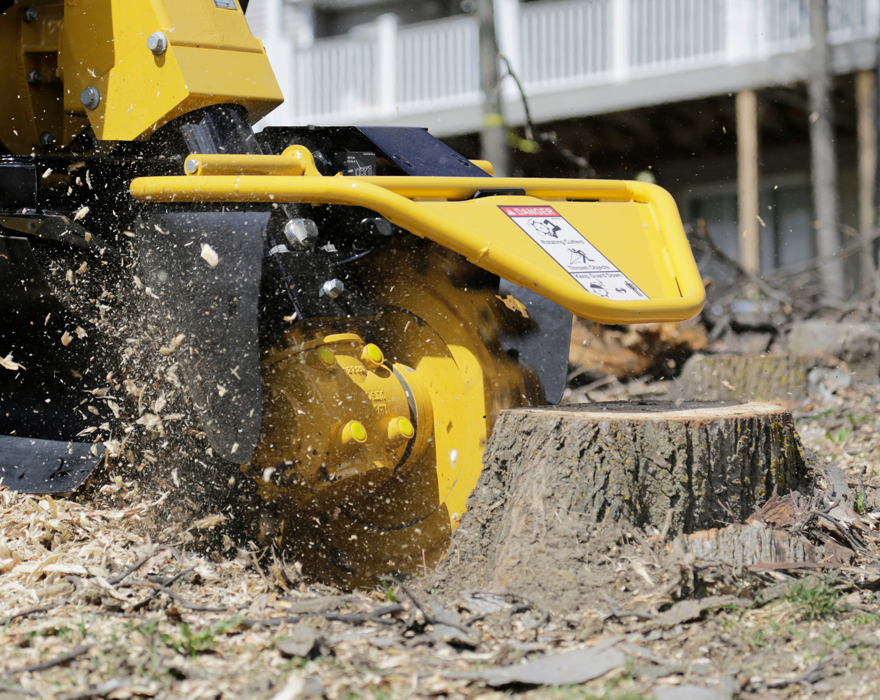 An action shot of a stump grinder removing a tree stump