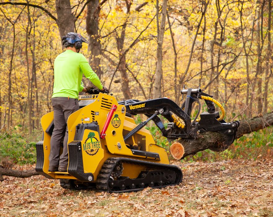 A man operating a mini skid steer