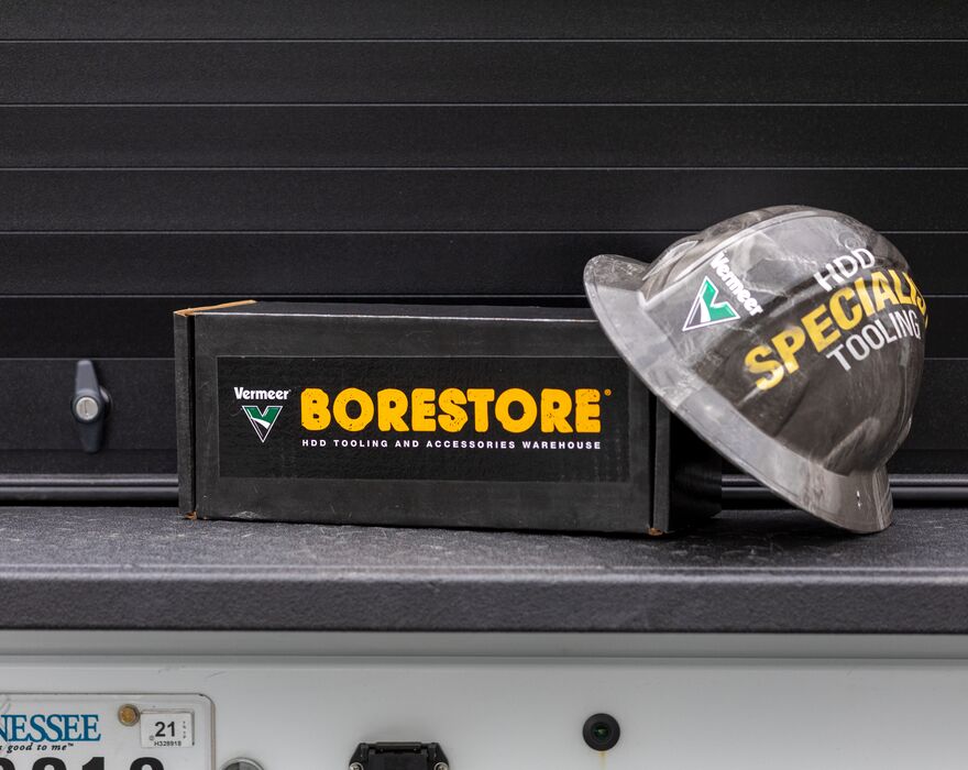 A black toolbox that says "Vermeer BORESTORE" with a Vermeer special tooling hardhat leaning on it.