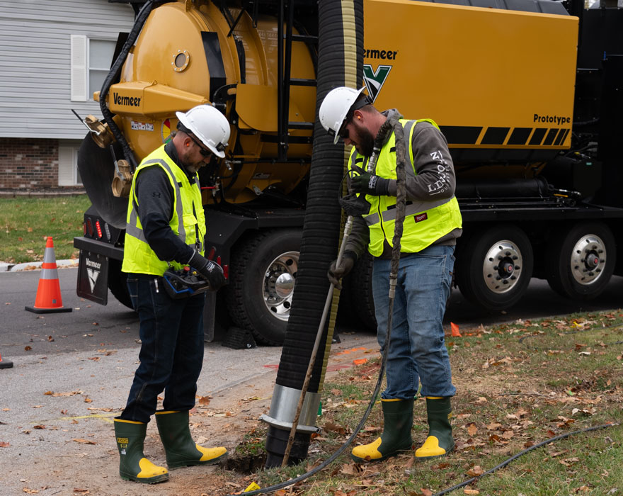 two men use a Vermeer vacuum truck