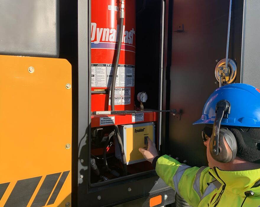 A man presses a button on the side of a vac truck