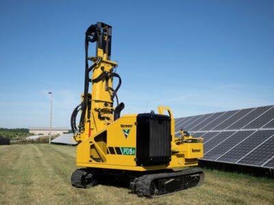 A pile driver sitting in a solar field