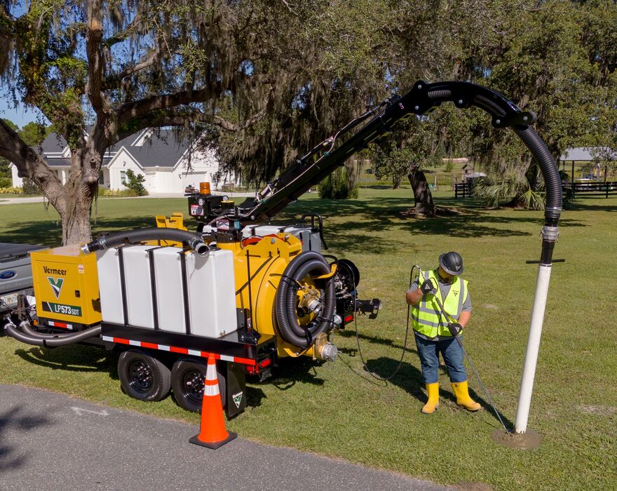 Vermeer LP573SDT vacuum excavator being operated on the side of the road in a residential neighborhood